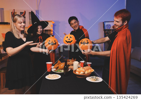 Friends enjoying a Halloween party at a bar making a toast Friends enjoying a Halloween party at a bar making a toast 135424269