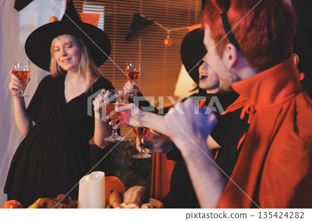 Friends enjoying a Halloween party at a bar making a toast 135424282