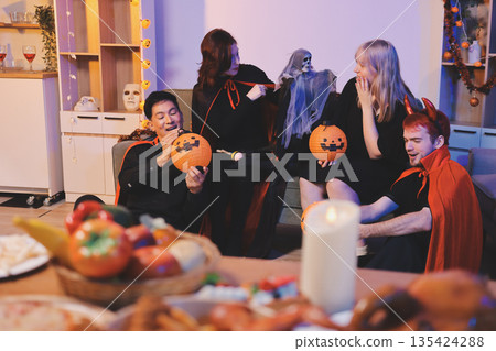 Friends enjoying a Halloween party at a bar making a toast 135424288