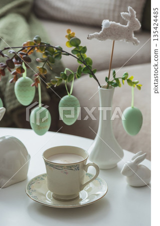 Spring Table Decor with Bunny Figurines, Hanging Eggs and Floral Cup of Coffee Spring Table Decor with Bunny Figurines, Hanging Eggs and Floral Cup of Coffee 135424485