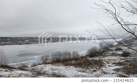A snowy landscape with a river and trees A snowy landscape with a river and trees 135424625