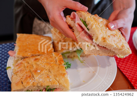 Close-up of an Italian woman making a hot panini sandwich in Italy Close-up of an Italian woman making a hot panini sandwich in Italy 135424962