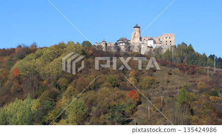 A hillside with a Stara Lubovna castle in the distance. A hillside with a Stara Lubovna castle in the distance. 135424986