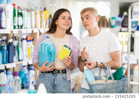 Couple man and woman choosing household chemicals in store 135425295