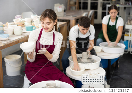 Young woman holding crafted clay cup Young woman holding crafted clay cup 135425327