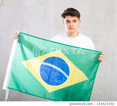 Male football fan holding Brazilian flag 135425358