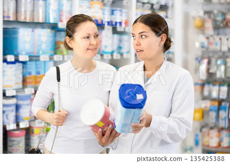 Female buyer consults with seller what baby food to buy 135425388
