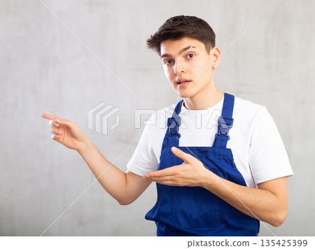 Worker or plumber in blue overalls expresses different emotions 135425399