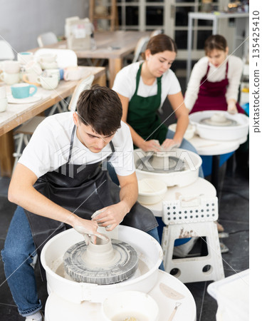 Young man working with pottery wheel 135425410