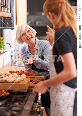 Woman, grandmother and cooking together in kitchen or teach recipe, prepare dinner or cook lunch with family. Senior mother, girl and conversation in home or talking about food or healthy vegetables Woman, grandmother and cooking together in kitchen or teach recipe, prepare dinner or cook lunch with family. Senior mother, girl and conversation in home or talking about food or healthy vegetables 135425478