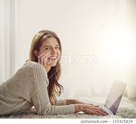 Laptop, smile and portrait of woman on carpet in home, relax and lying on floor. Computer, happy face and person on ground typing, writing blog for social media or email, internet or web mockup space 135425634