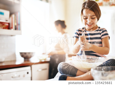 Messy, happy and child baking in the kitchen with parent for bonding, food and dessert. Funny young girl mixing flour in a bowl with chaos, energy or cooking with happiness while playing for learning Messy, happy and child baking in the kitchen with parent for bonding, food and dessert. Funny young girl mixing flour in a bowl with chaos, energy or cooking with happiness while playing for learning 135425681