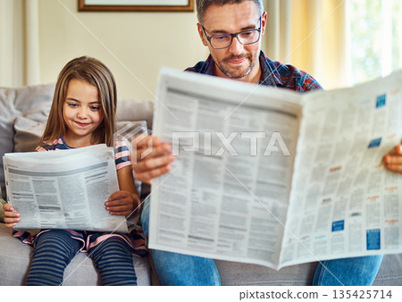 Happy father, daughter and reading newspaper on sofa for knowledge, literature or news in living room at home. Dad, child and smile for family bonding, learning or education on lounge couch together Happy father, daughter and reading newspaper on sofa for knowledge, literature or news in living room at home. Dad, child and smile for family bonding, learning or education on lounge couch together 135425714