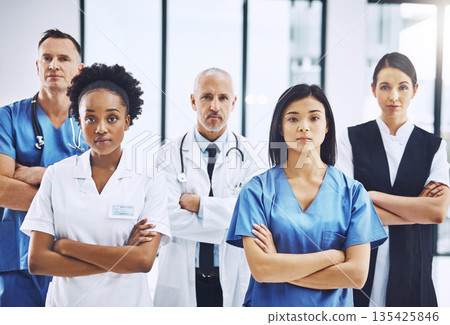 Medical, crossed arms and portrait of group of doctors standing in the hallway with confidence. Serious, diversity and team of professional healthcare workers in a medicare clinic or hospital. Medical, crossed arms and portrait of group of doctors standing in the hallway with confidence. Serious, diversity and team of professional healthcare workers in a medicare clinic or hospital. 135425846