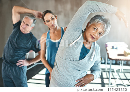 Stretching, physical therapy and old woman with personal trainer in class for fitness, wellness or rehabilitation. Health, workout or retirement with senior patient and physiotherapist for warm up Stretching, physical therapy and old woman with personal trainer in class for fitness, wellness or rehabilitation. Health, workout or retirement with senior patient and physiotherapist for warm up 135425850