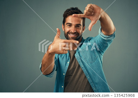 Frame, hands and face portrait of man in studio on gray background with happiness, confident and smile. Photographer, happy and male person with hand sign for picture, photography and finger border 135425908