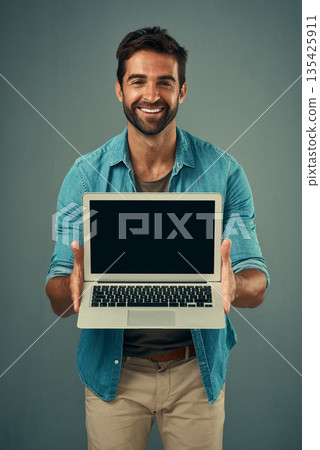 Happy man, laptop and portrait with mockup screen for advertising or marketing against grey studio background. Male person showing technology or computer display or mock up space for advertisement 135425911