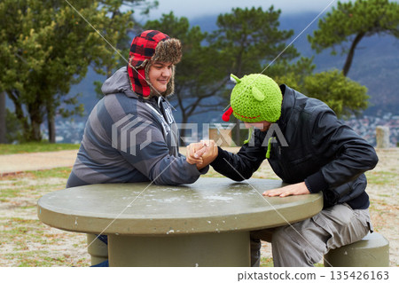 Arm wrestling, friends and winning outdoor at table for sports, challenge and exercise. Strong, conflict and men holding hands for competition, power and muscle match, training or workout in park. 135426163