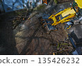 A bulldozer collects branches after pruning trees. View from above 135426232