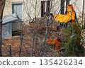 A bulldozer collects branches after pruning trees 135426234