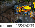 A bulldozer collects branches after pruning trees. View from above 135426235