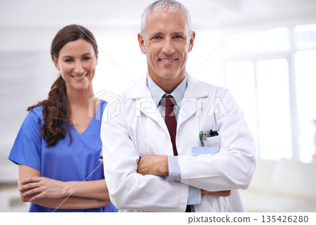 Doctors, man and woman in portrait with arms crossed for health, wellness and team in hospital. Mature healthcare expert, nurse and professional with medical knowledge, solidarity and smile in clinic Doctors, man and woman in portrait with arms crossed for health, wellness and team in hospital. Mature healthcare expert, nurse and professional with medical knowledge, solidarity and smile in clinic 135426280