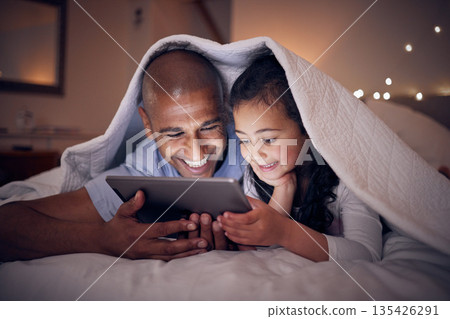Father, kid and smile with tablet at night under blanket of online games, reading ebook or storytelling app. Happy dad, girl child or watch cartoon movie on digital tech, media or internet in bedroom Father, kid and smile with tablet at night under blanket of online games, reading ebook or storytelling app. Happy dad, girl child or watch cartoon movie on digital tech, media or internet in bedroom 135426291