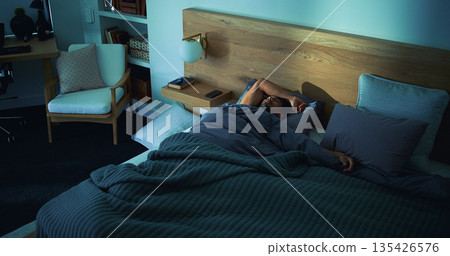 Sleeping, rest and man in bed in home on weekend with exhaustion, fatigue or burnout with dreaming. Relax, above and tired male person with nap in bedroom with blanket for comfort in apartment. Sleeping, rest and man in bed in home on weekend with exhaustion, fatigue or burnout with dreaming. Relax, above and tired male person with nap in bedroom with blanket for comfort in apartment. 135426576