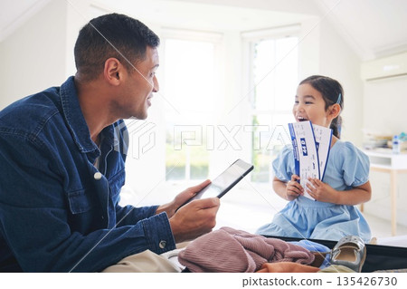 Happy father, child and tickets for flight, travel or holiday vacation together at home. Excited little girl and dad packing for weekend trip or getaway in celebration with boarding pass in the house 135426730