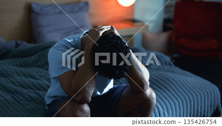 Insomnia, night and man in bedroom with stress for burnout, exhausted and fatigue for mental health. Tired, dark and person with upset, sad and anxiety for sleepless, bad dream and frustrated in home 135426754