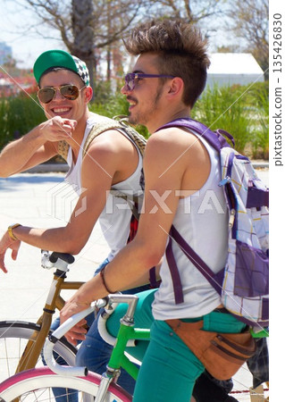 Men, students and friends with back, bicycle and sustainable transportation on road in summer sunshine. Young gen z people, retro bike and outdoor together in street with travel on university campus Men, students and friends with back, bicycle and sustainable transportation on road in summer sunshine. Young gen z people, retro bike and outdoor together in street with travel on university campus 135426830