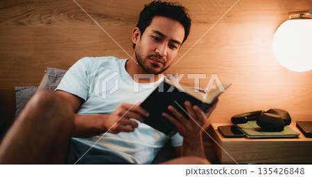 Reading, novel and man in bed at night in home with relax for hobby, knowledge or entertainment. Calm, late and male person in bedroom with fiction story, book or literature on weekend in apartment. Reading, novel and man in bed at night in home with relax for hobby, knowledge or entertainment. Calm, late and male person in bedroom with fiction story, book or literature on weekend in apartment. 135426848