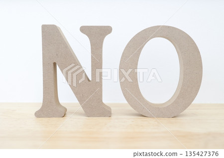 一個類似木頭的物體,上面寫著字母「NO」。它給人一種強烈的否定或拒絕的感覺。 一個類似木頭的物體,上面寫著字母「NO」。它給人一種強烈的否定或拒絕的感覺。 135427376