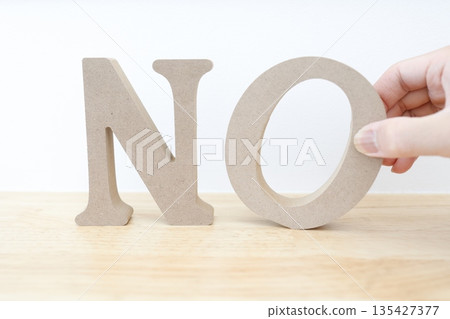 A wooden-like object with the letter "NO." It evokes a strong image of negation or rejection. 135427377