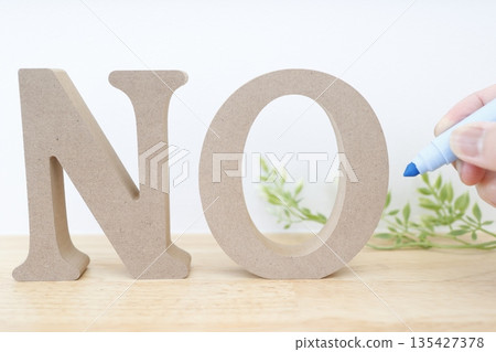 一個類似木頭的物體,上面寫著字母「NO」。它給人一種強烈的否定或拒絕的感覺。 一個類似木頭的物體,上面寫著字母「NO」。它給人一種強烈的否定或拒絕的感覺。 135427378