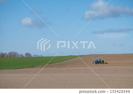 Tractor working in a spring field 135428349