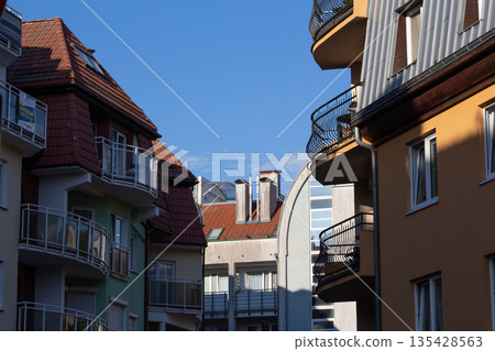 Urban scene with multicolored buildings and clear blue sky showing modern 135428563