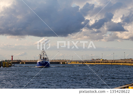 Boat navigates through harbor with cloudy skies in the background during late Boat navigates through harbor with cloudy skies in the background during late 135428622