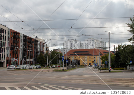 Urban intersection featuring modern and historical architecture on a cloudy day Urban intersection featuring modern and historical architecture on a cloudy day 135428633
