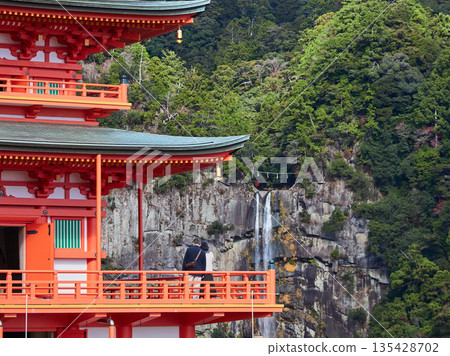 Tourists enjoying the scenery of the three-story pagoda of Seiganto-ji Temple and Nachi Falls in Nachikatsuura, a tourist attraction in Wakayama Prefecture, in autumn Tourists enjoying the scenery of the three-story pagoda of Seiganto-ji Temple and Nachi Falls in Nachikatsuura, a tourist attraction in Wakayama Prefecture, in autumn 135428702