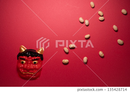 Setsubun material featuring beans in a wooden box and a demon mask photographed from above 135428714