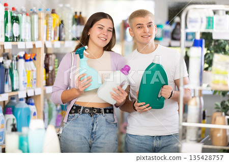 Young couple choosing spray and detergent in department store Young couple choosing spray and detergent in department store 135428757