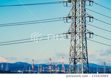 A landscape of towering power lines and distant mountains, emphasizing warm and cool colors 135428964