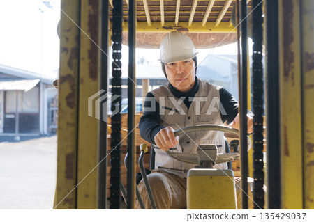 Worker operating a forklift Worker operating a forklift 135429037