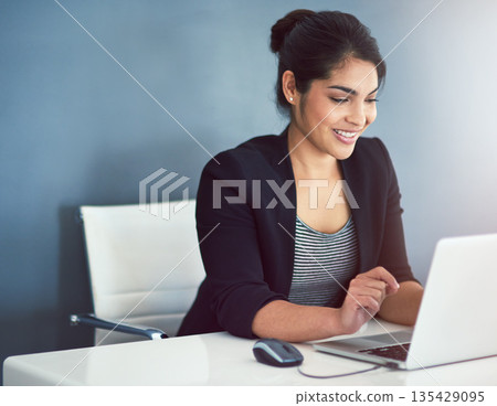 Technology, businesswoman with laptop and at her desk of a modern workplace office. Social networking or online communication, connectivity and female person typing an email at her workstation 135429095