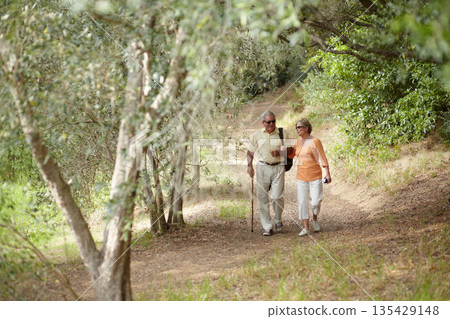 Hiking, nature and senior couple for fitness, walking stick and retirement exercise, wellness support or path in forest. Elderly people in woods for cardio, travel and health journey or trekking Hiking, nature and senior couple for fitness, walking stick and retirement exercise, wellness support or path in forest. Elderly people in woods for cardio, travel and health journey or trekking 135429148