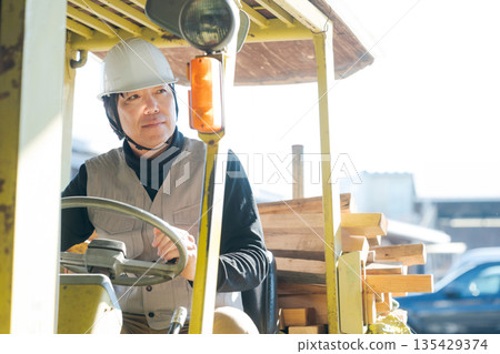 Worker operating a forklift Worker operating a forklift 135429374