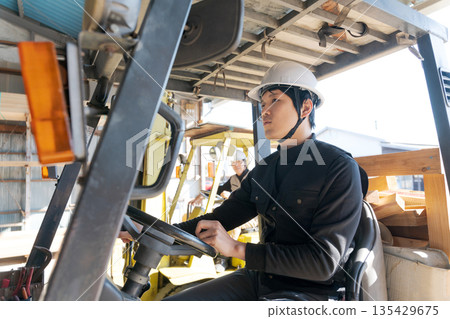 Worker operating a forklift Worker operating a forklift 135429675