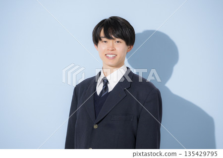 Image of upper body of high school boy looking at camera on light blue background, studying for exams, career path, etc. 135429795