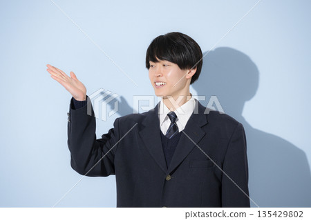 A high school boy's upper body pose looking at the camera against a light blue background. Recommended pose for introducing yourself and your career path. 135429802